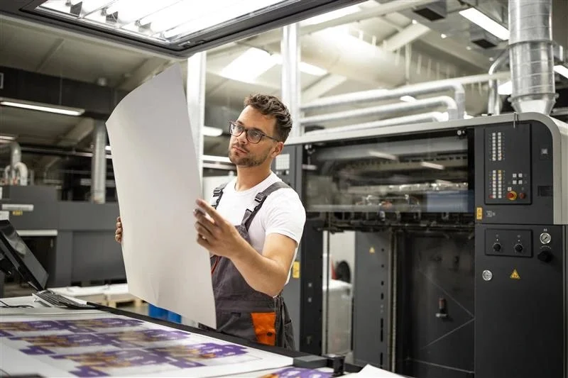 Prepress experts checking a color proof on press